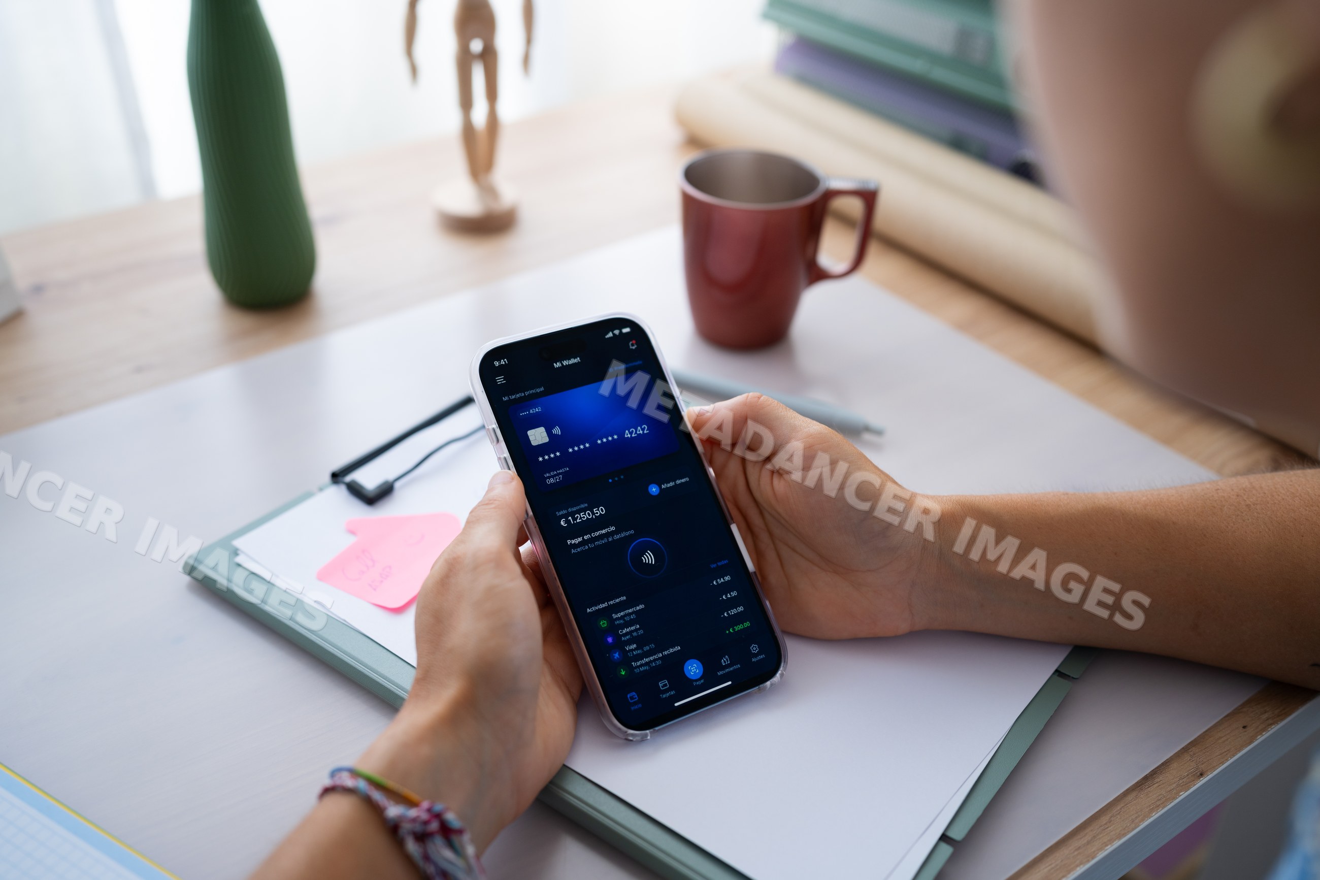 White person using digital wallet app on mobile phone at desk in Spain