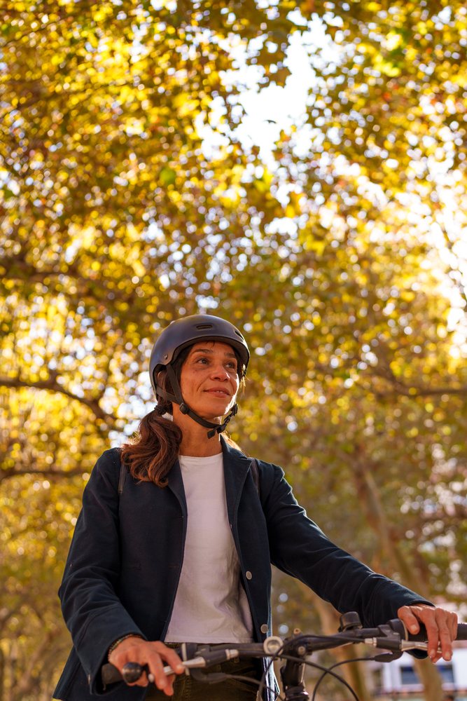 Hispanic woman riding bicycle outdoors in autumn in Málaga