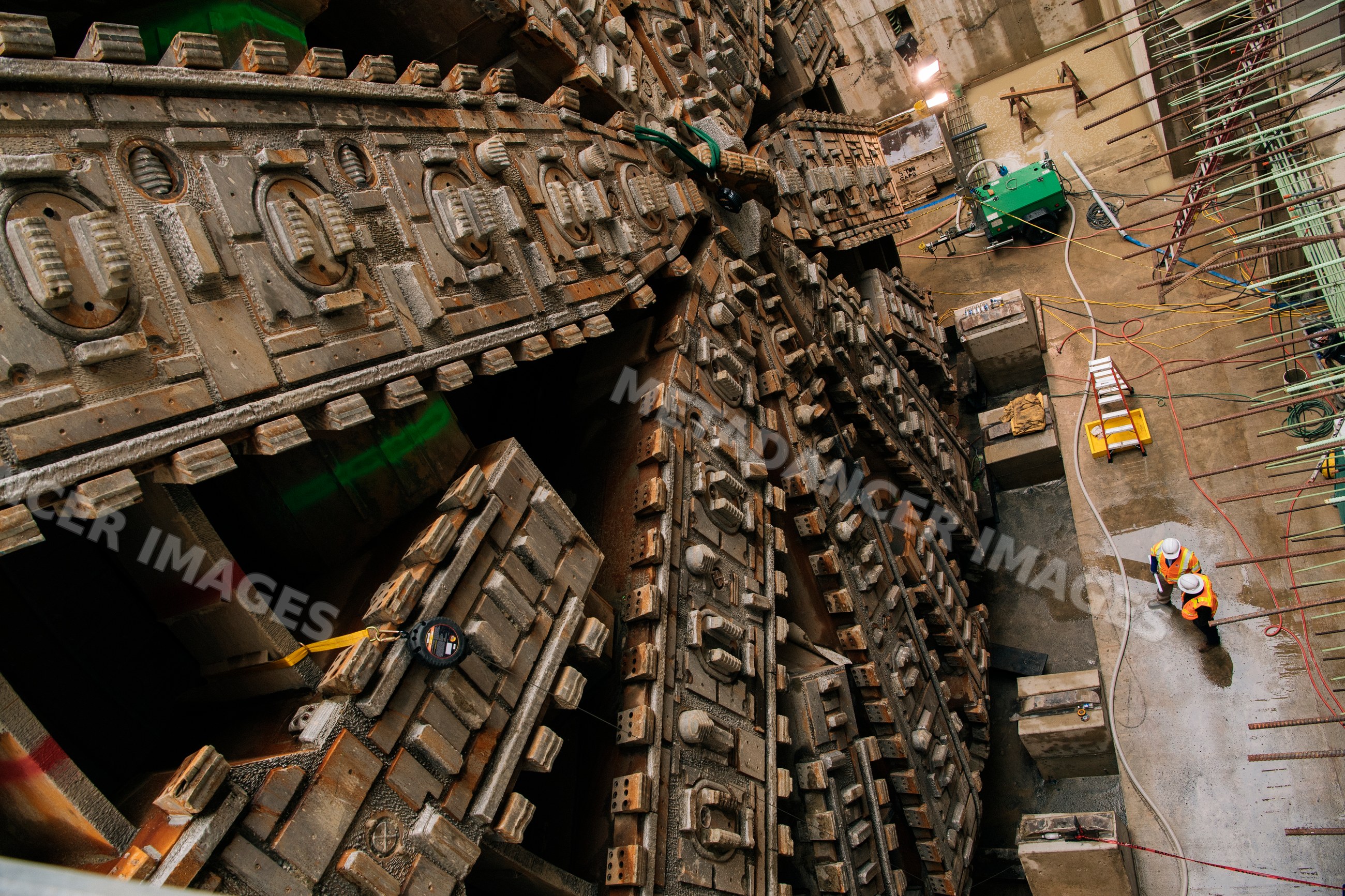 Construction white workers inspect a large tunnel boring machine