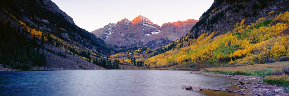 Maroon bells mountain peaks with autumn aspen trees by alpine lake