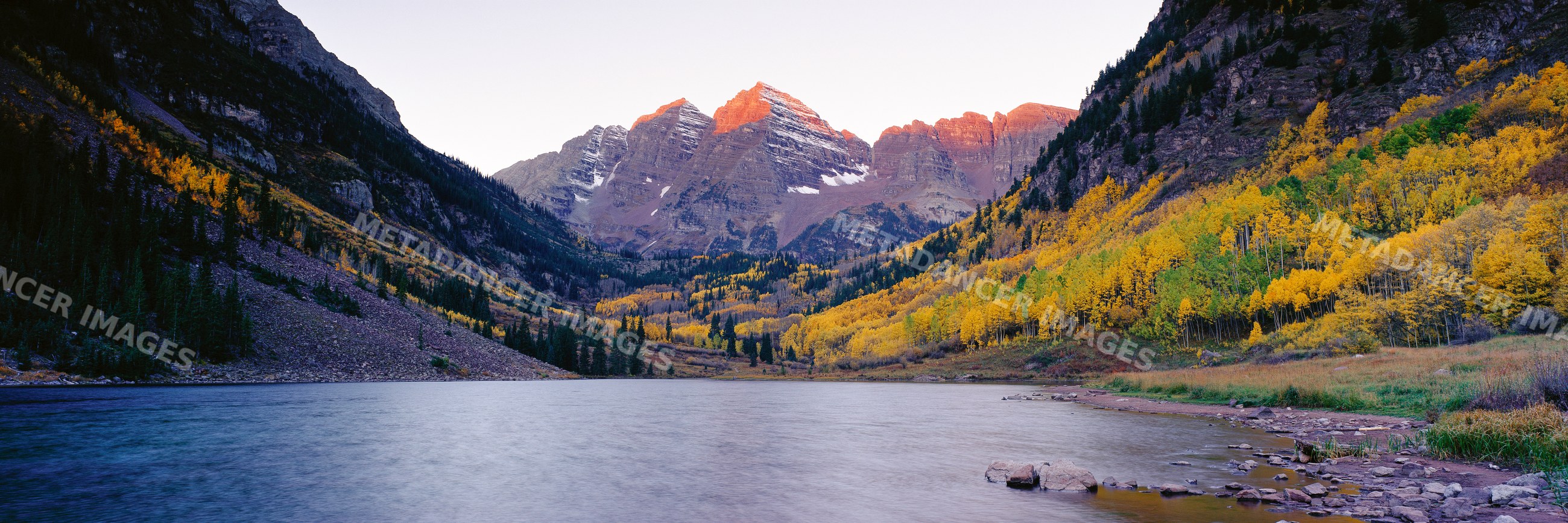 Maroon bells mountain peaks with autumn aspen trees by alpine lake