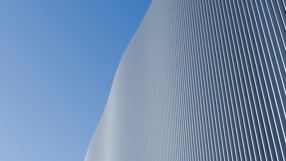 Curved modern building facade with vertical metal panels