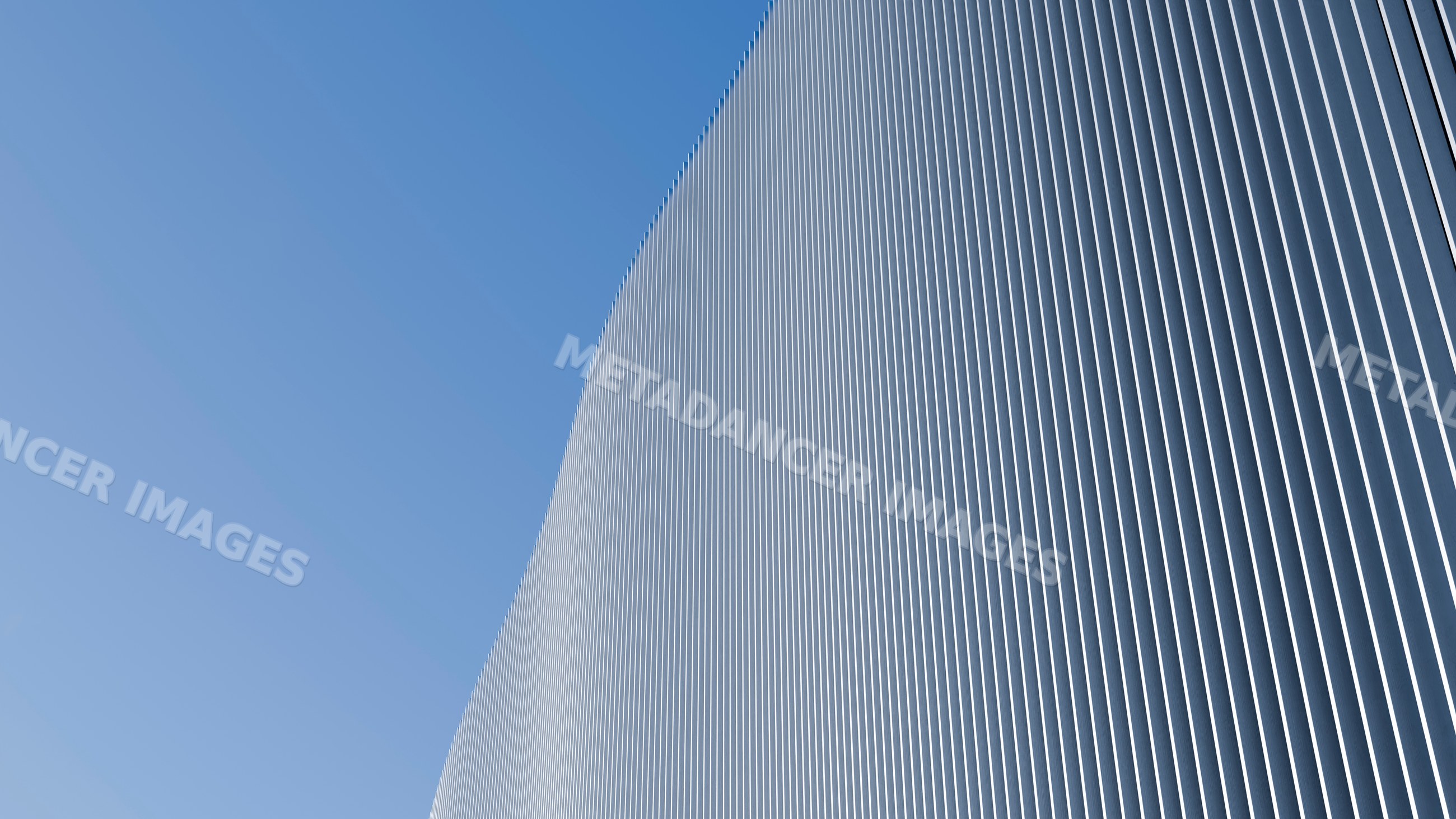 Curved modern building facade with vertical metal panels