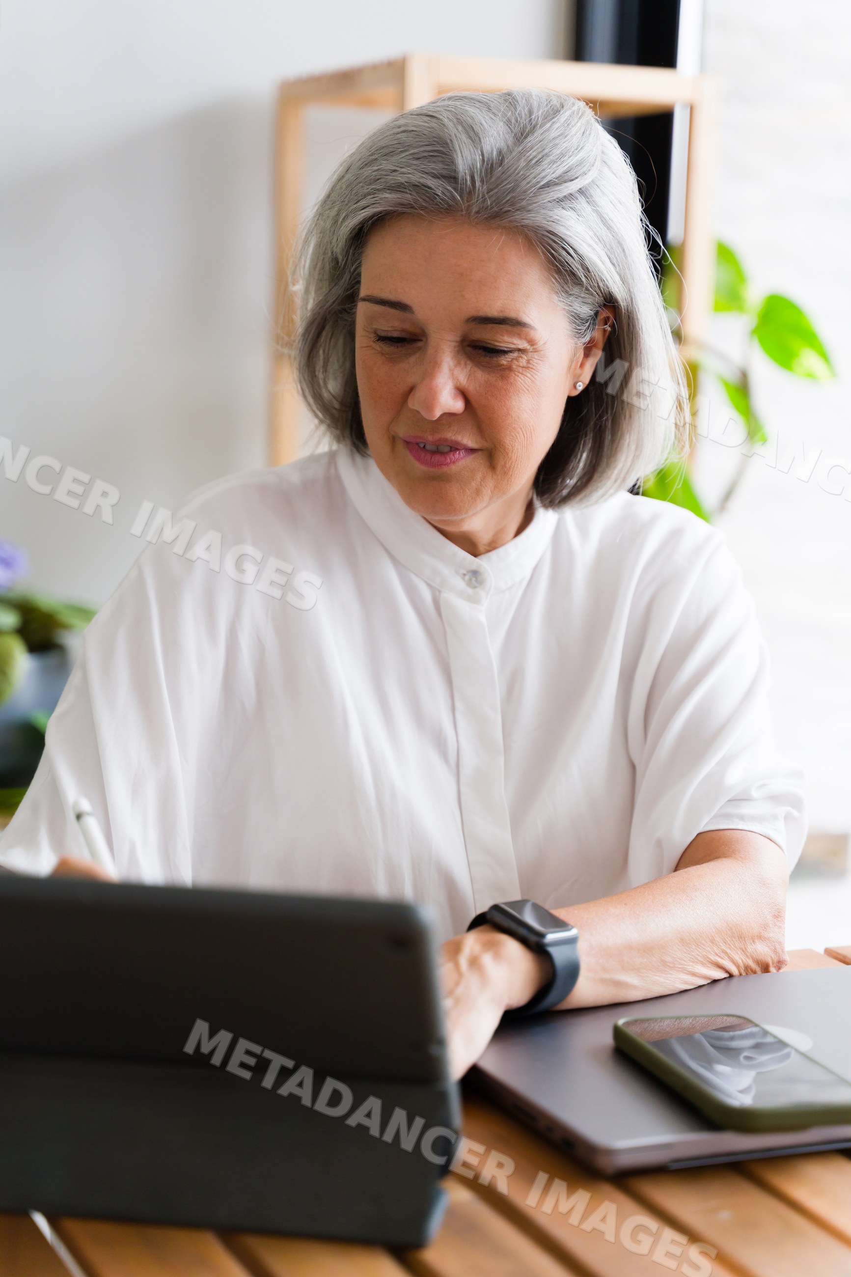 Mature white woman working on tablet