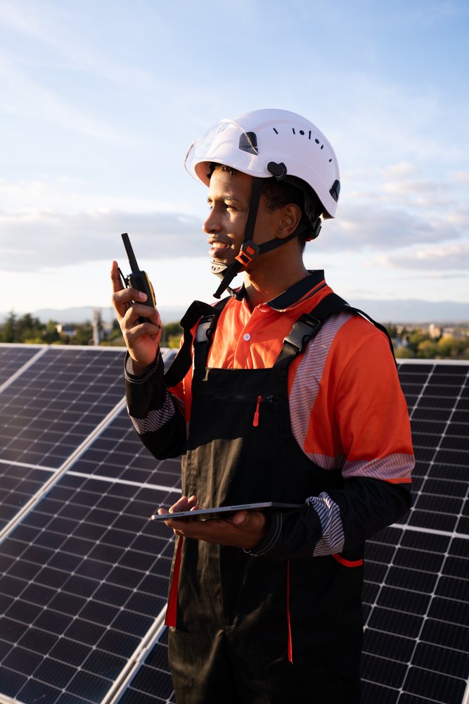 Worker communicating next to solar panels in Madrid solar energy field