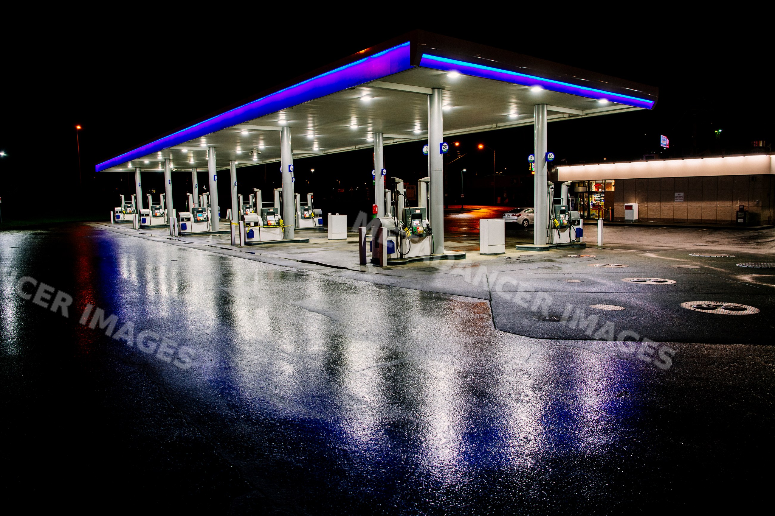 Gas station with fuel pumps lit at night in Tacoma, WA, USA