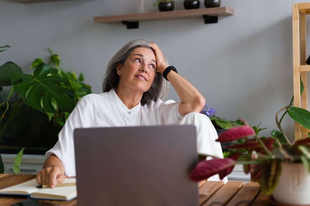 Mature white woman working thoughtfully