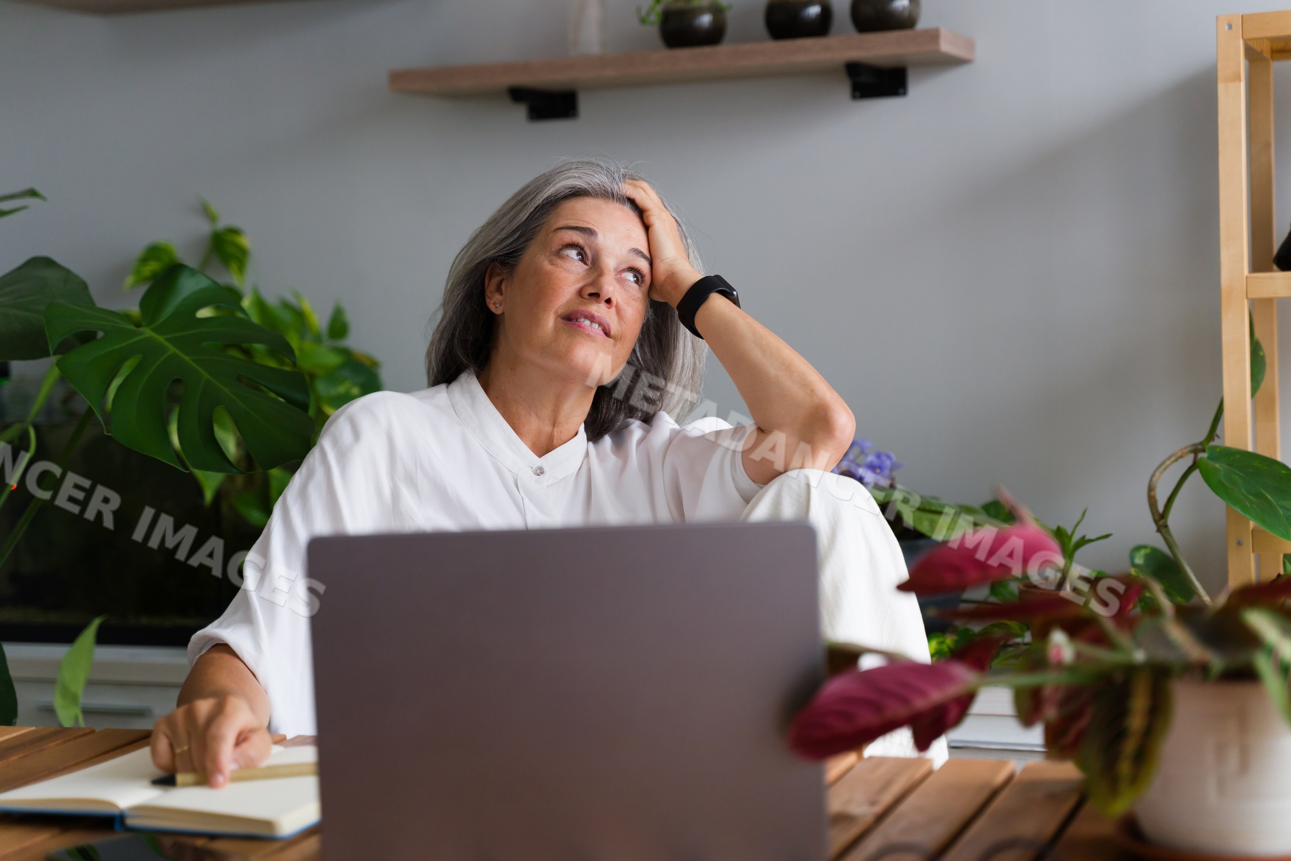 Mature white woman working thoughtfully