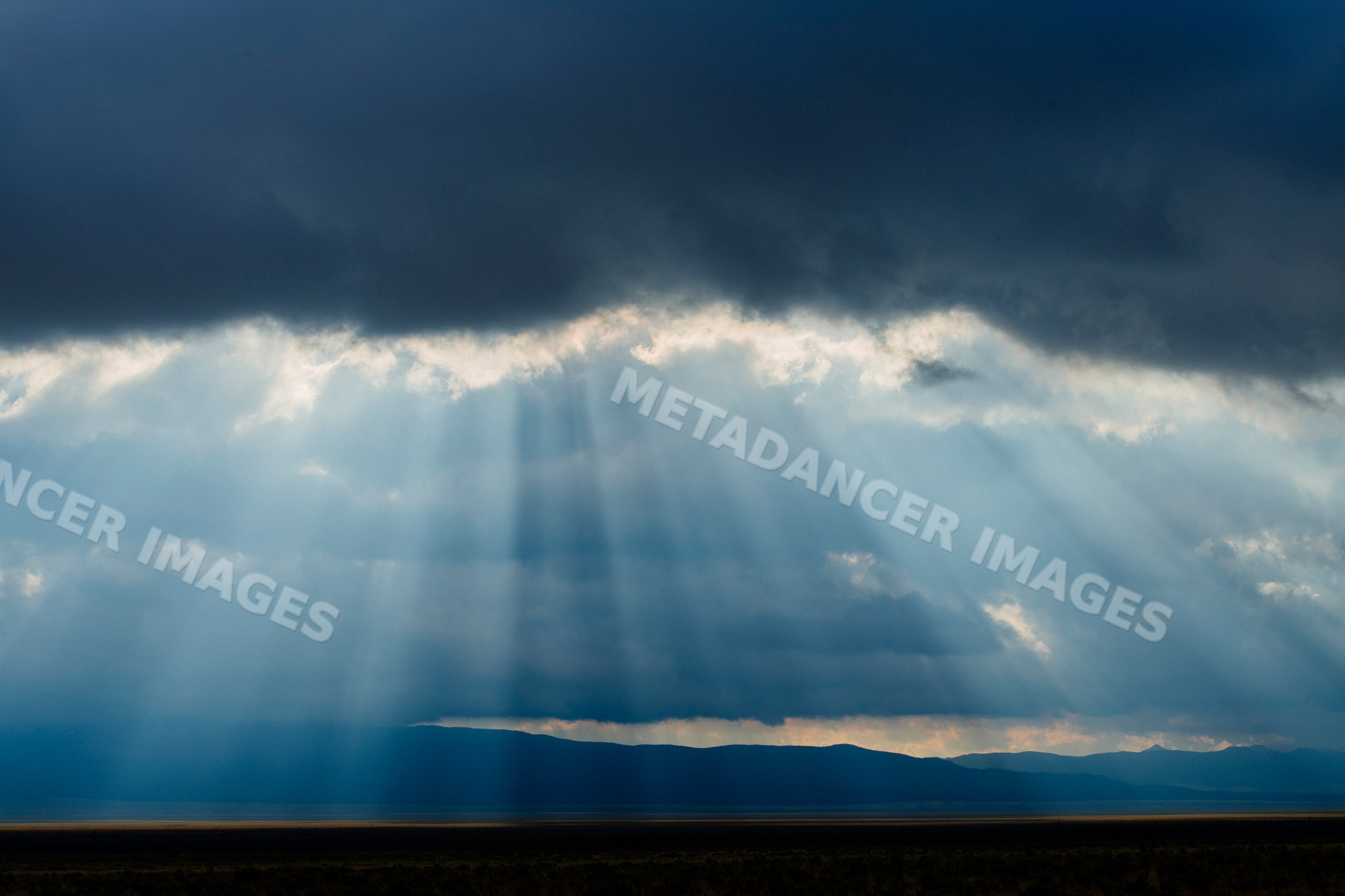 Sun rays breaking through clouds over Nevada mountains