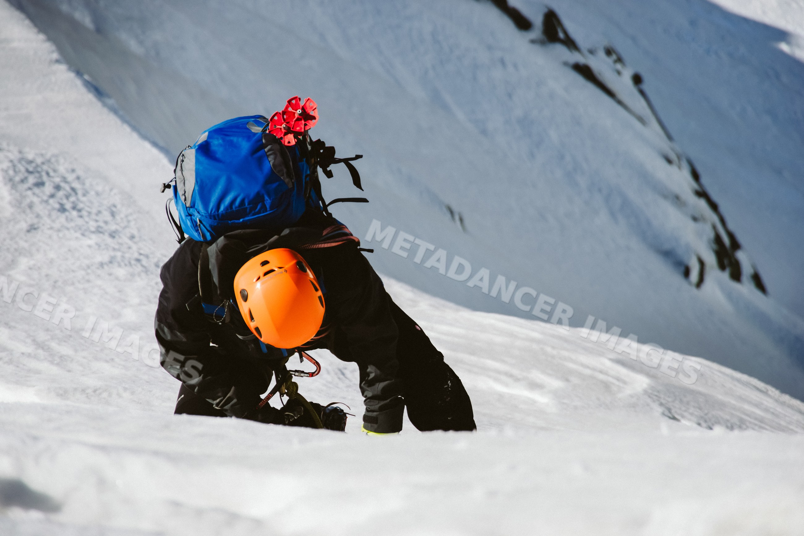 Mountaineer climbing snowy mountain slope