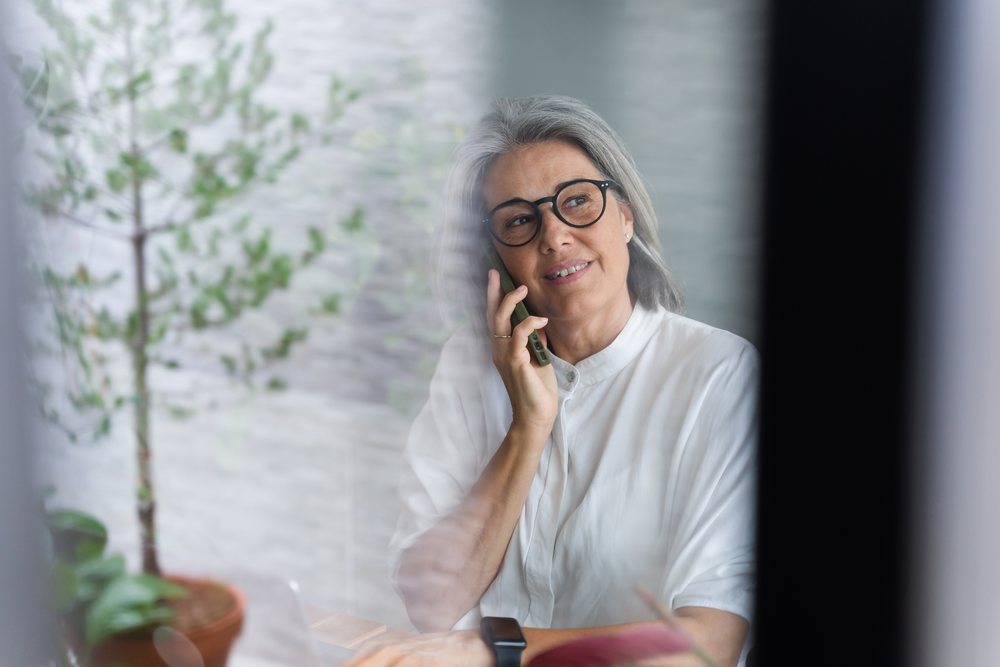Middle-aged white woman talking on phone indoors