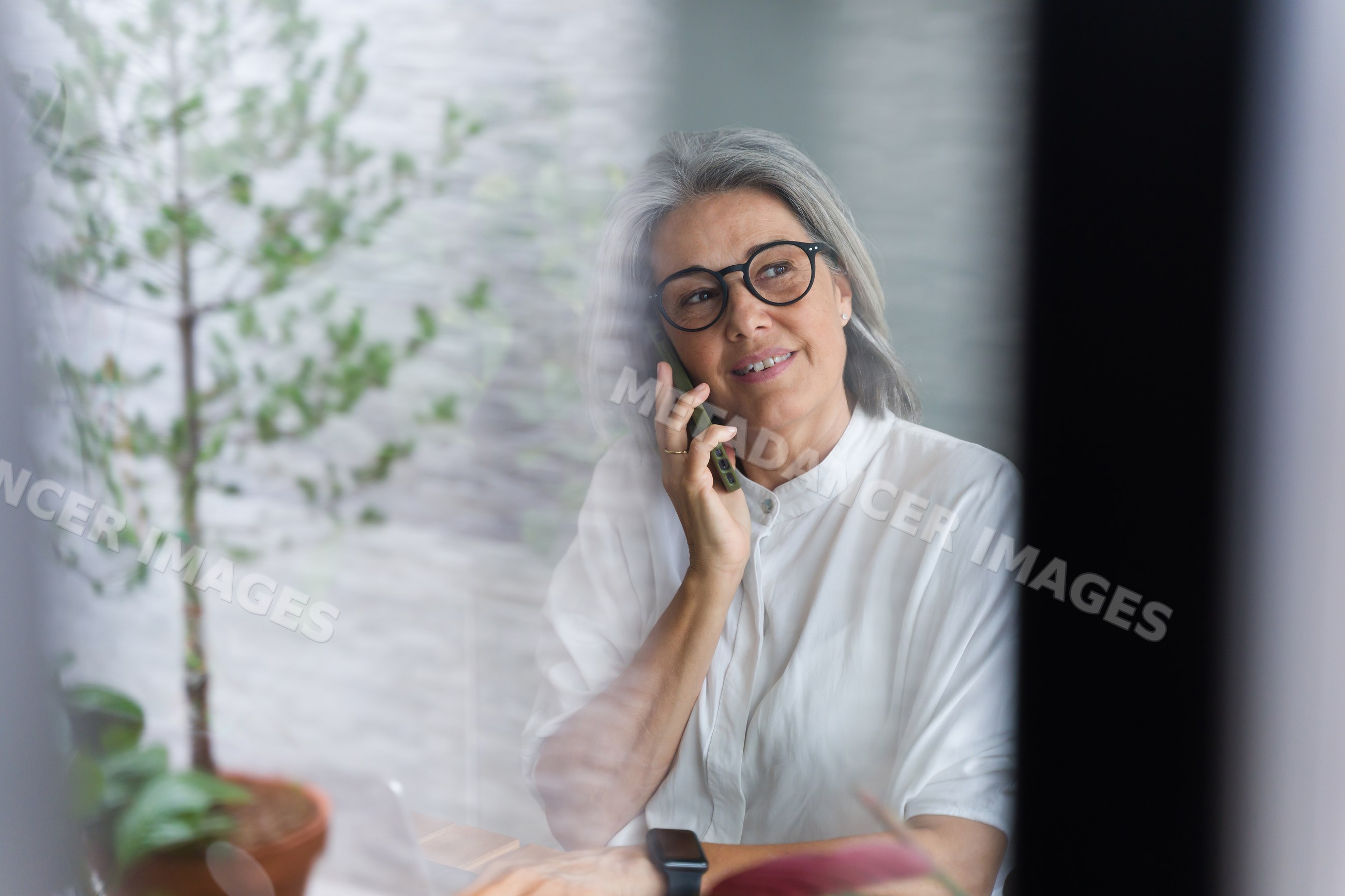 Middle-aged white woman talking on phone indoors