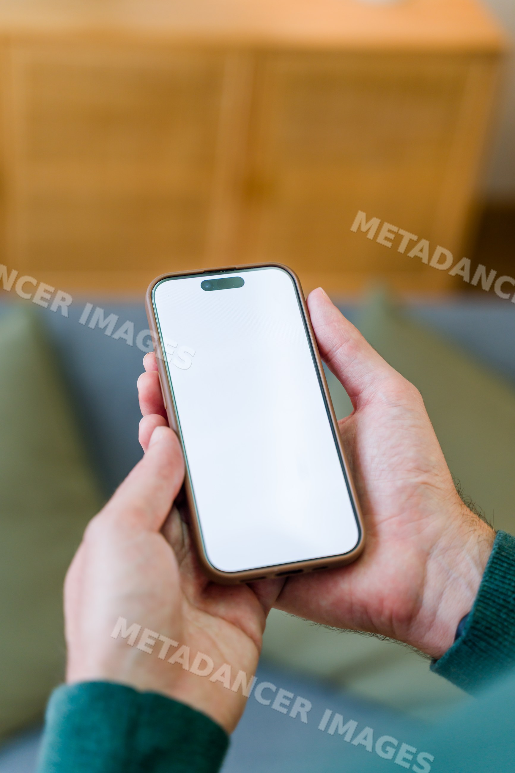 Smartphone with blank screen held in hands indoors