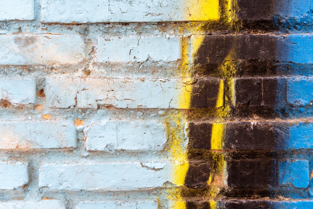Painted brick wall with weathered blue, yellow