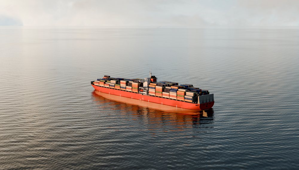 A large container cargo ship sails across calm ocean waters