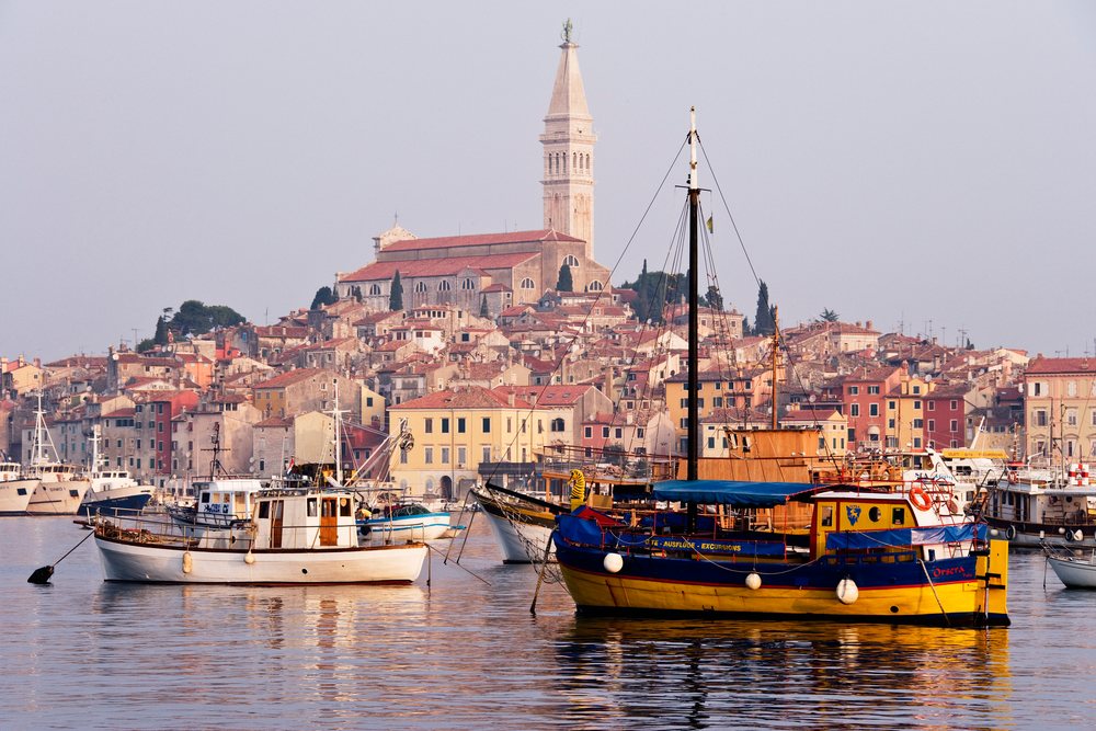 Town of rovinj with boats in harbor and church tower