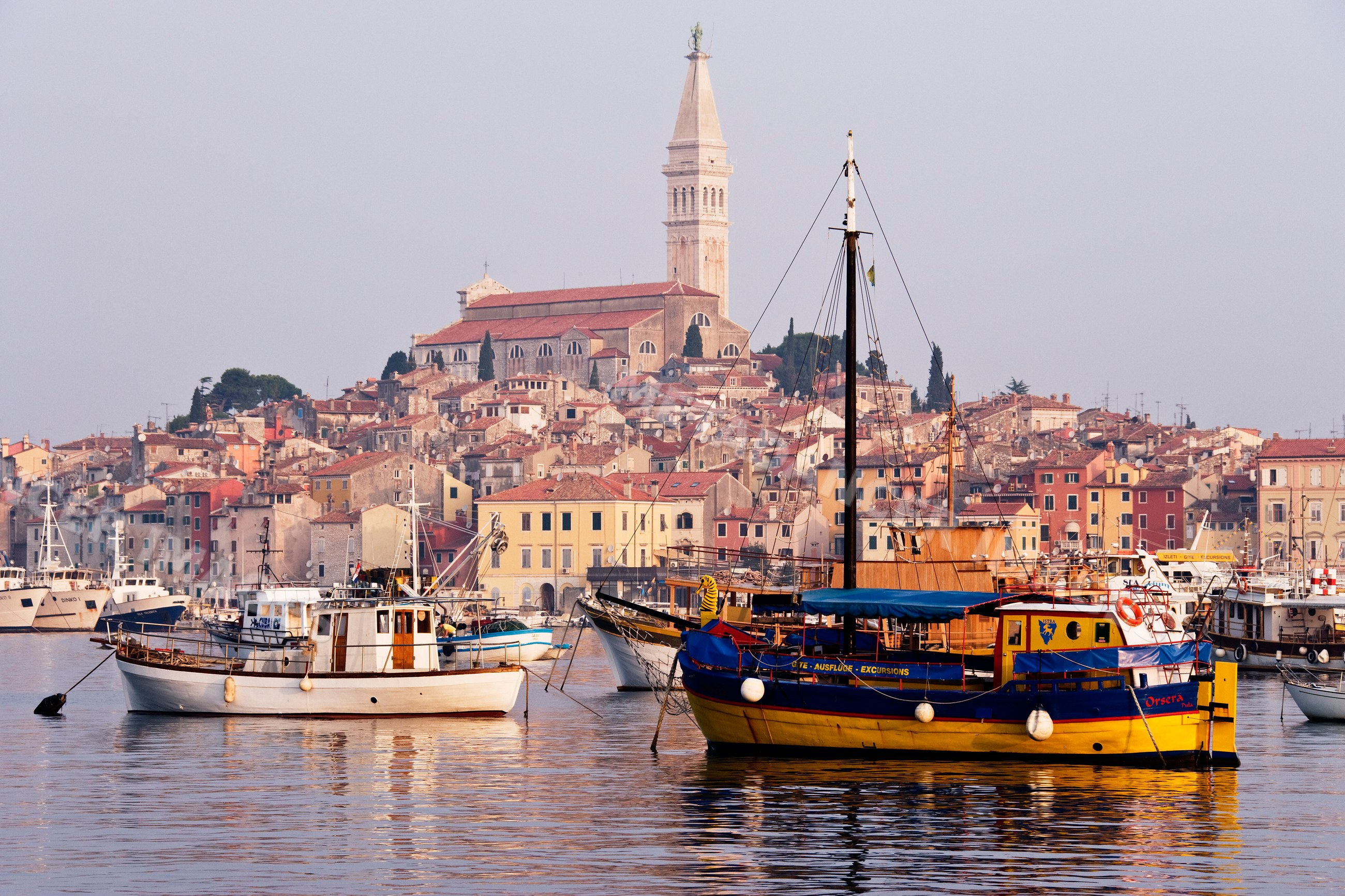 Town of rovinj with boats in harbor and church tower