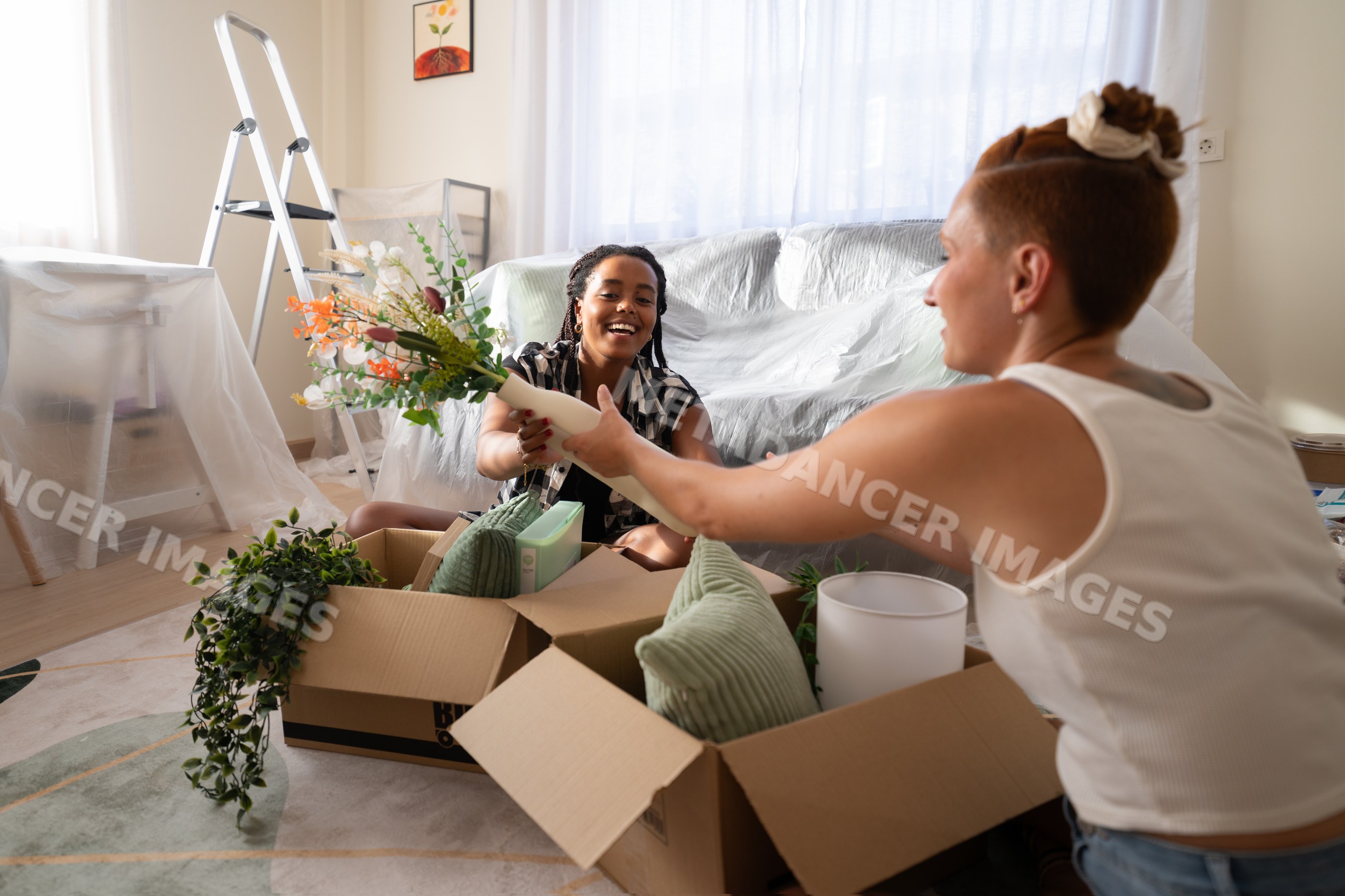 Two African American and white women unpacking and decorating their