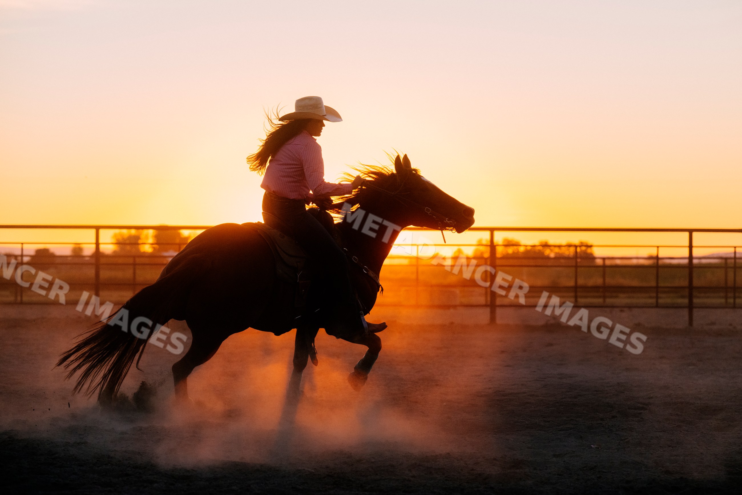 White woman riding horse at sunset in Southwest USA arena