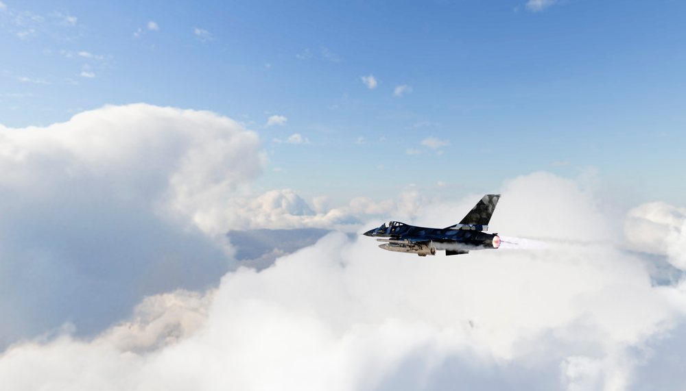A military fighter jet flying through clouds with afterburner blazing