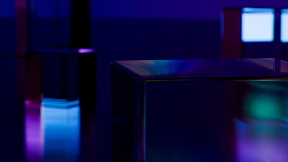 Glass cubes illuminated by neon blue and purple lights with reflective