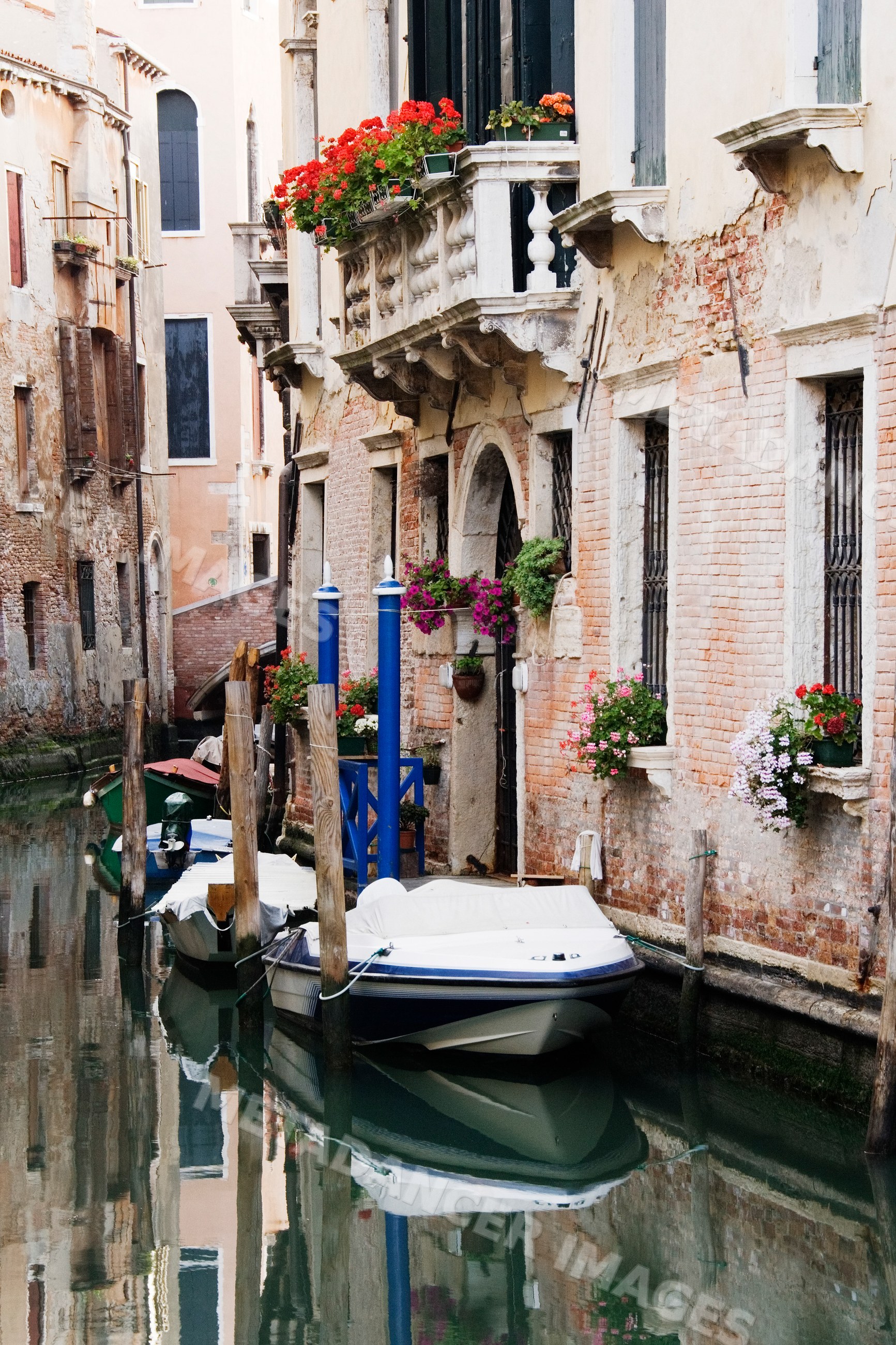 Boats anchored on canal beside historic buildings italy