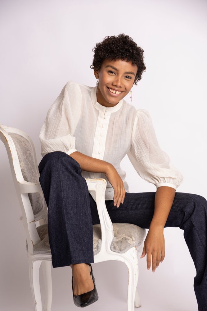 Hispanic woman sitting on vintage chair smiling