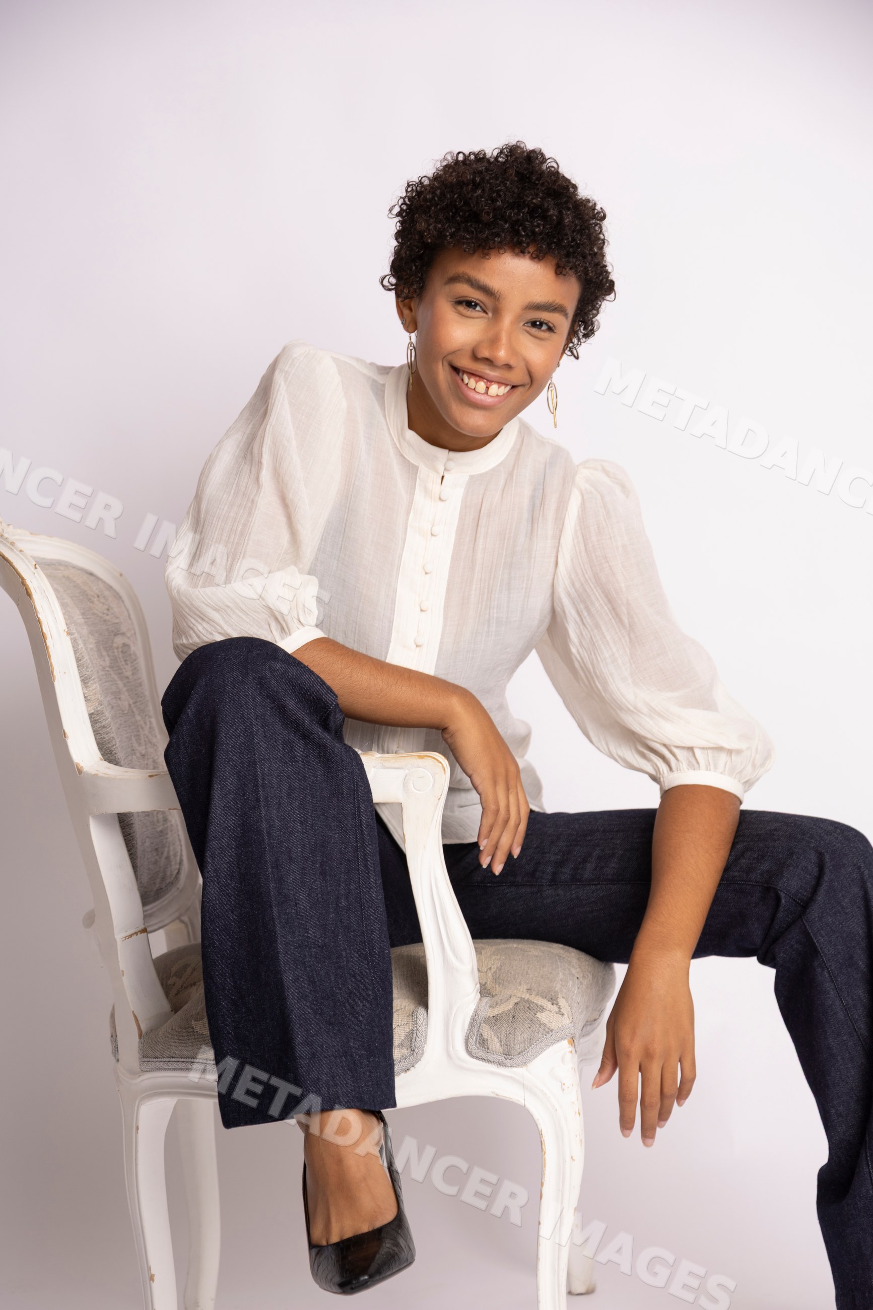 Hispanic woman sitting on vintage chair smiling
