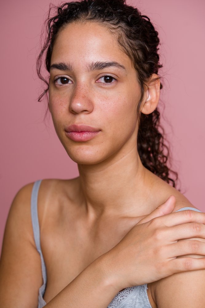 Close-up portrait of Hispanic woman with natural skin and curly hair