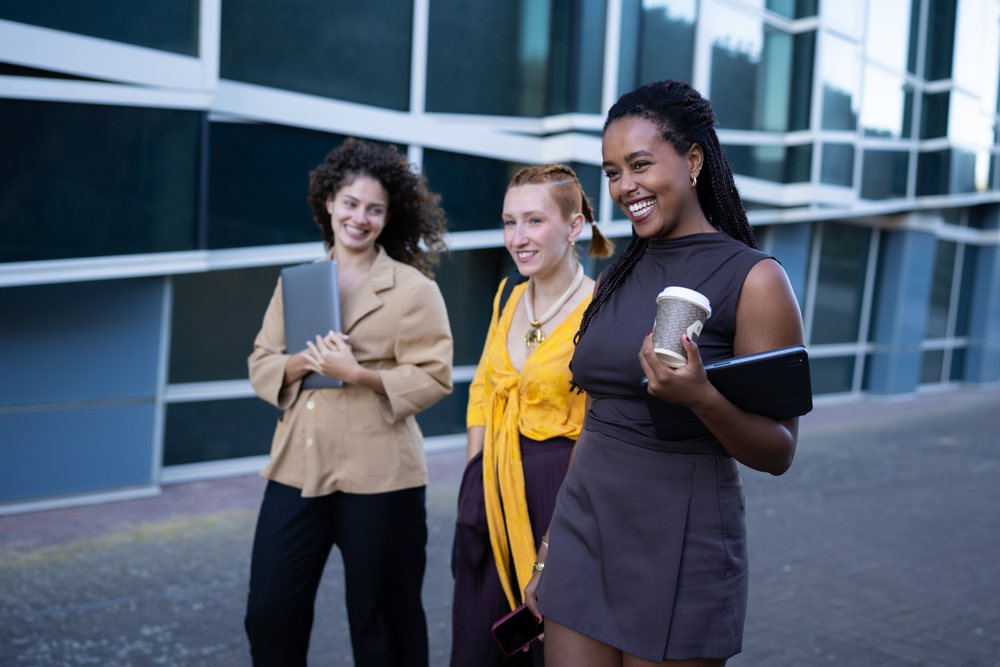 Three African American and white women laughing and walking outside