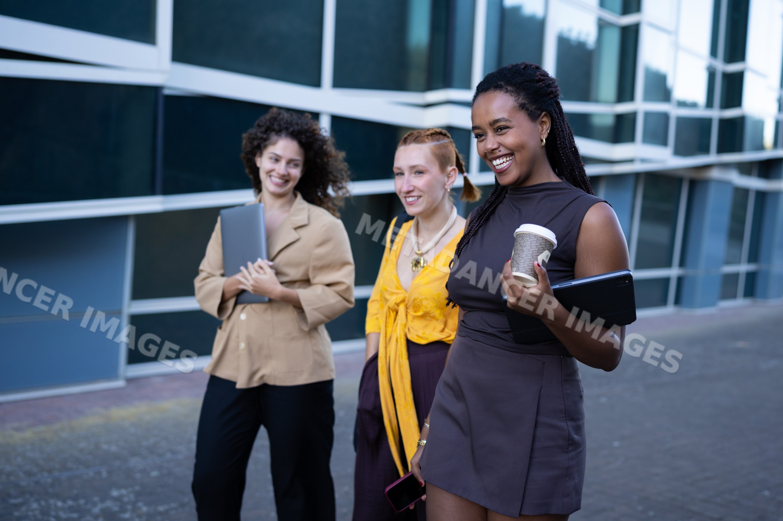 Three African American and white women laughing and walking outside