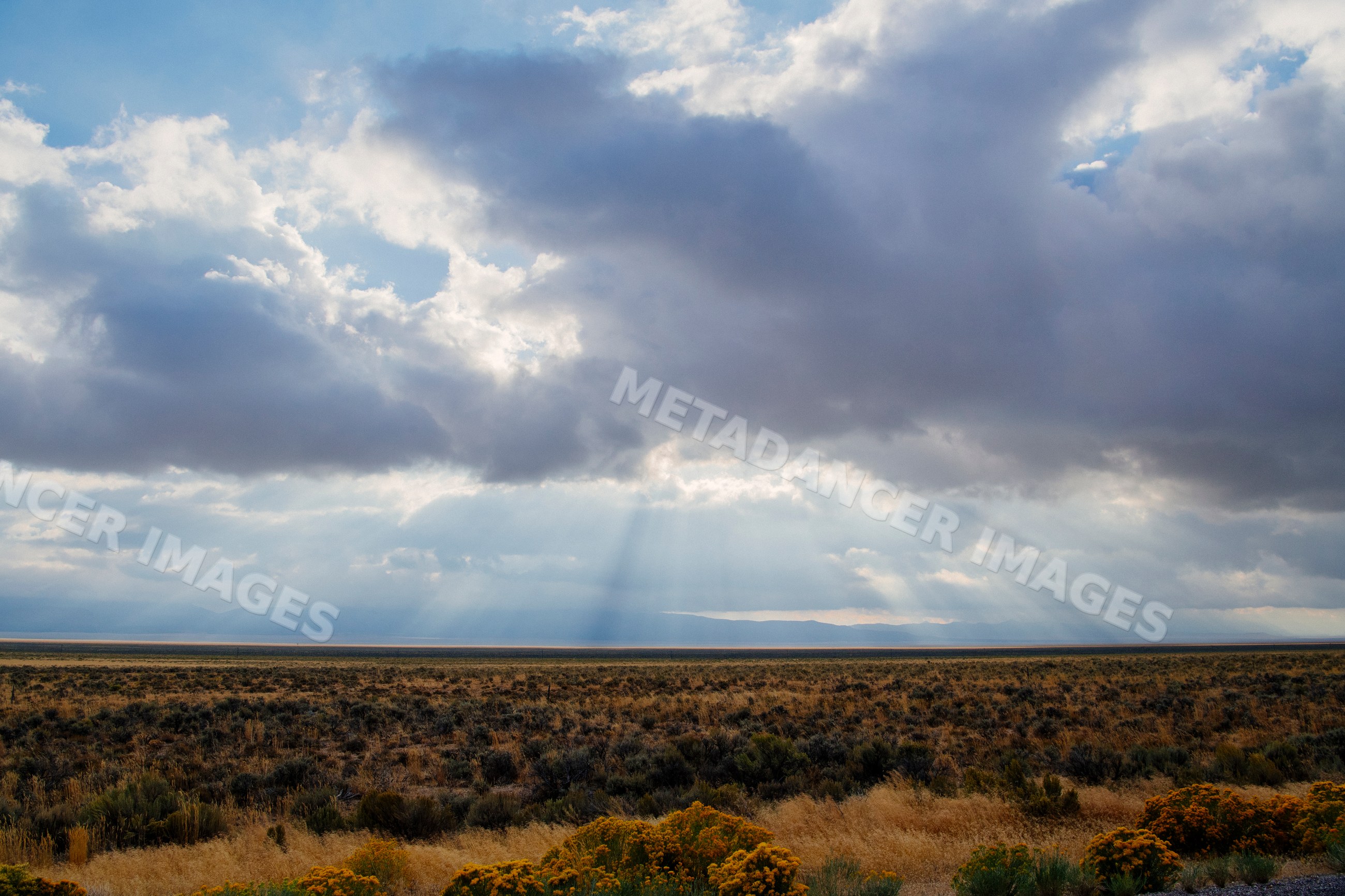 Sunrays breaking through clouds over Nevada desert landscape