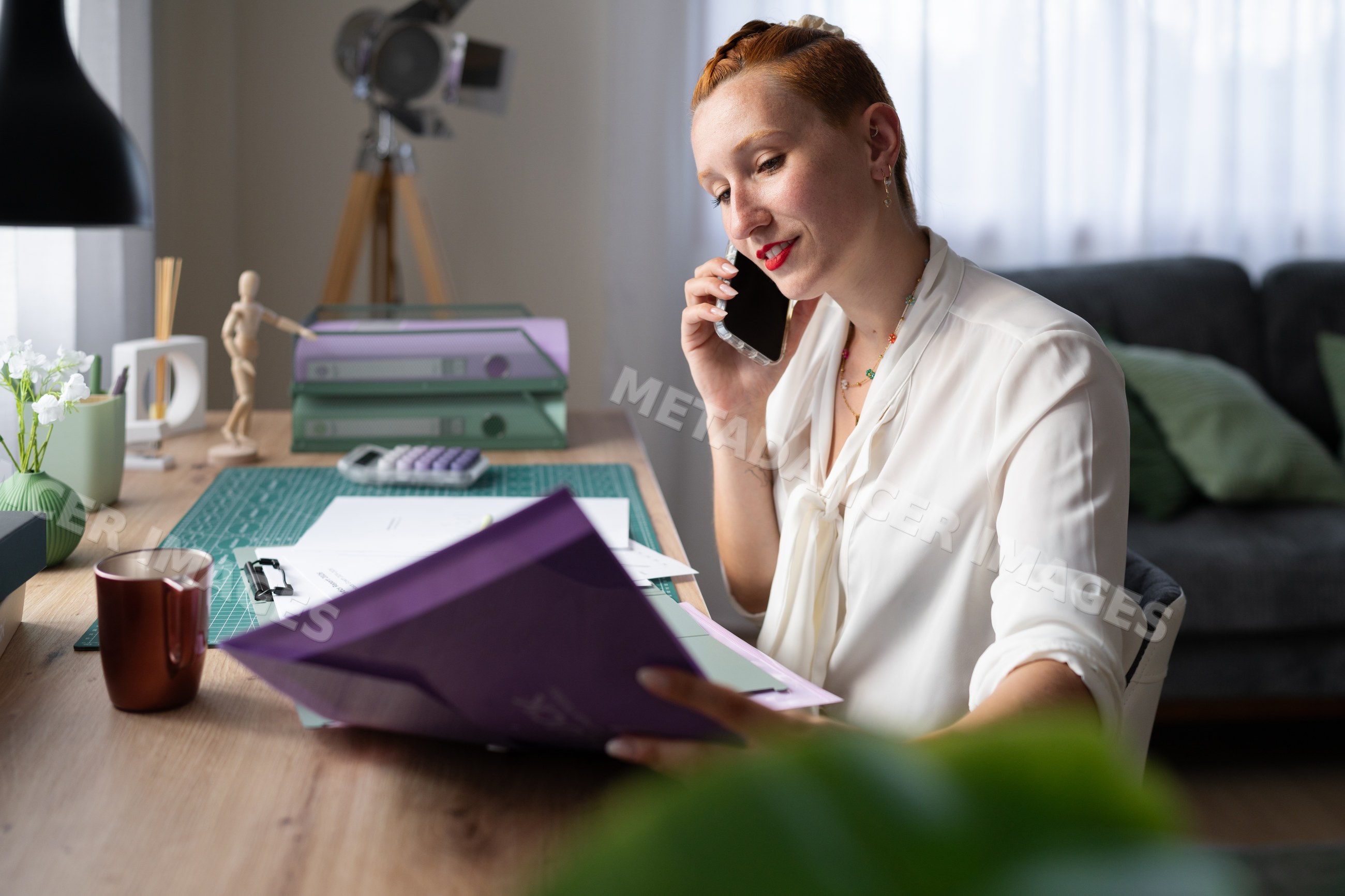 A white woman working from home talks on phone