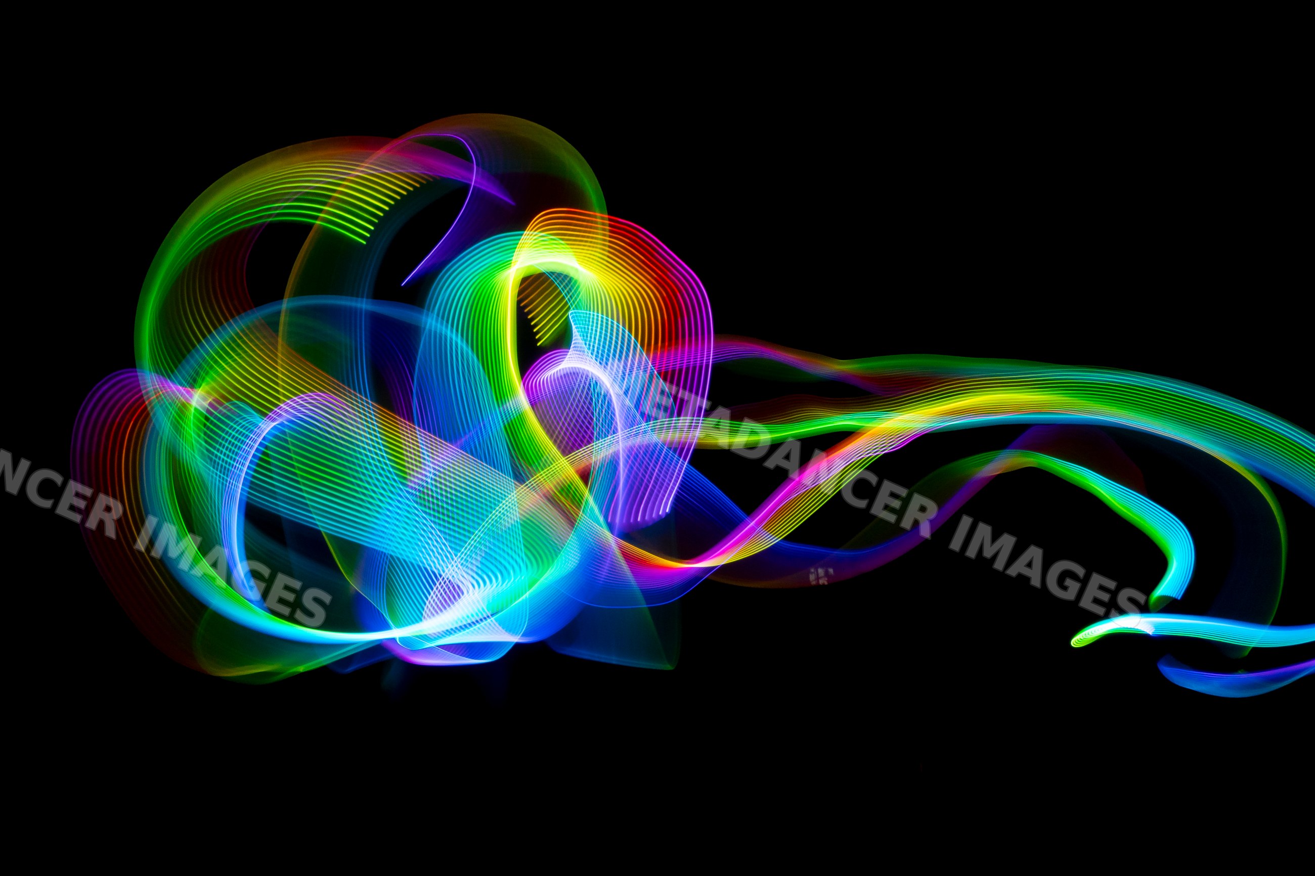 Colorful led light painting with swirling abstract trails on a black