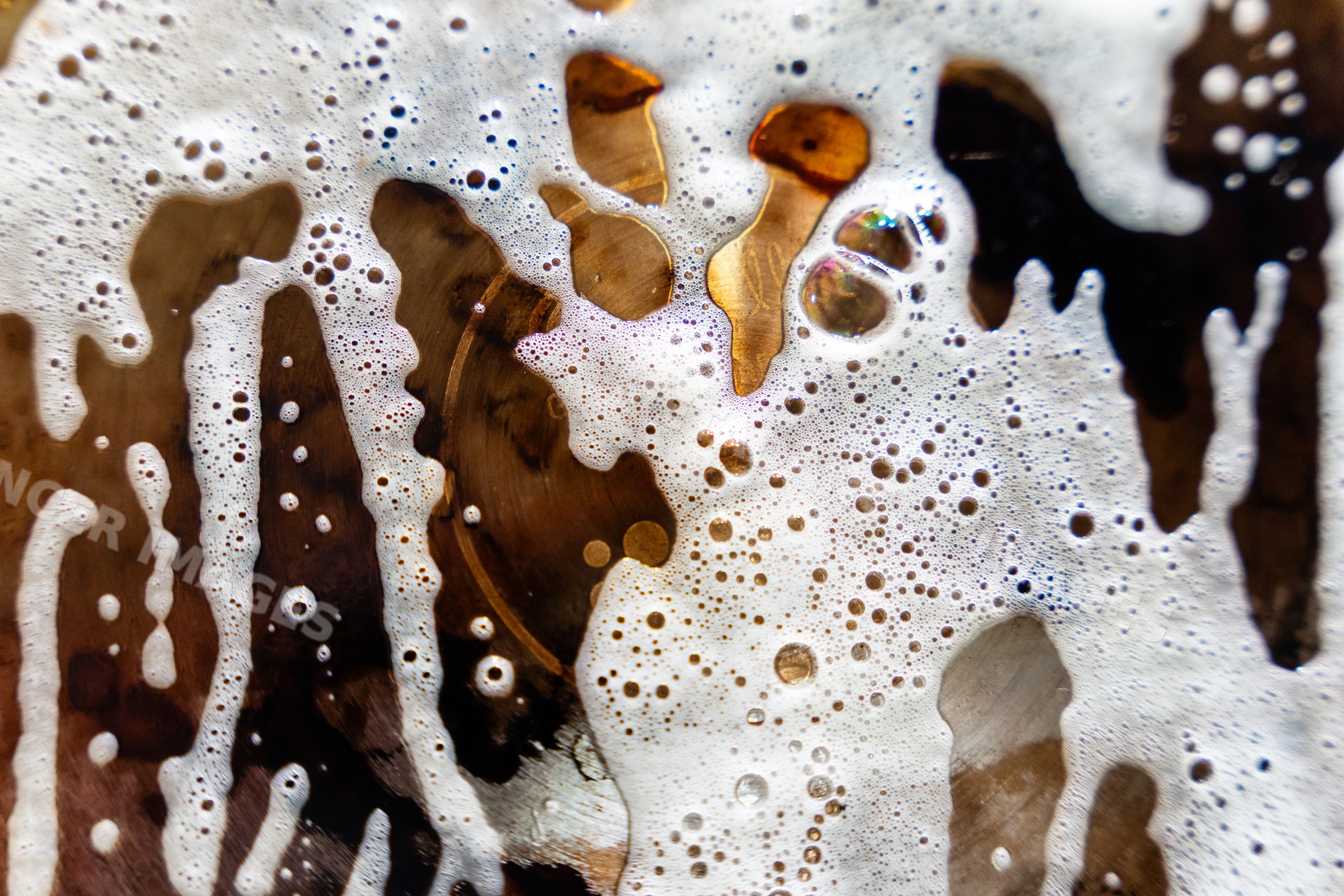 Close-up of foam bubbles on surface of brown liquid drink