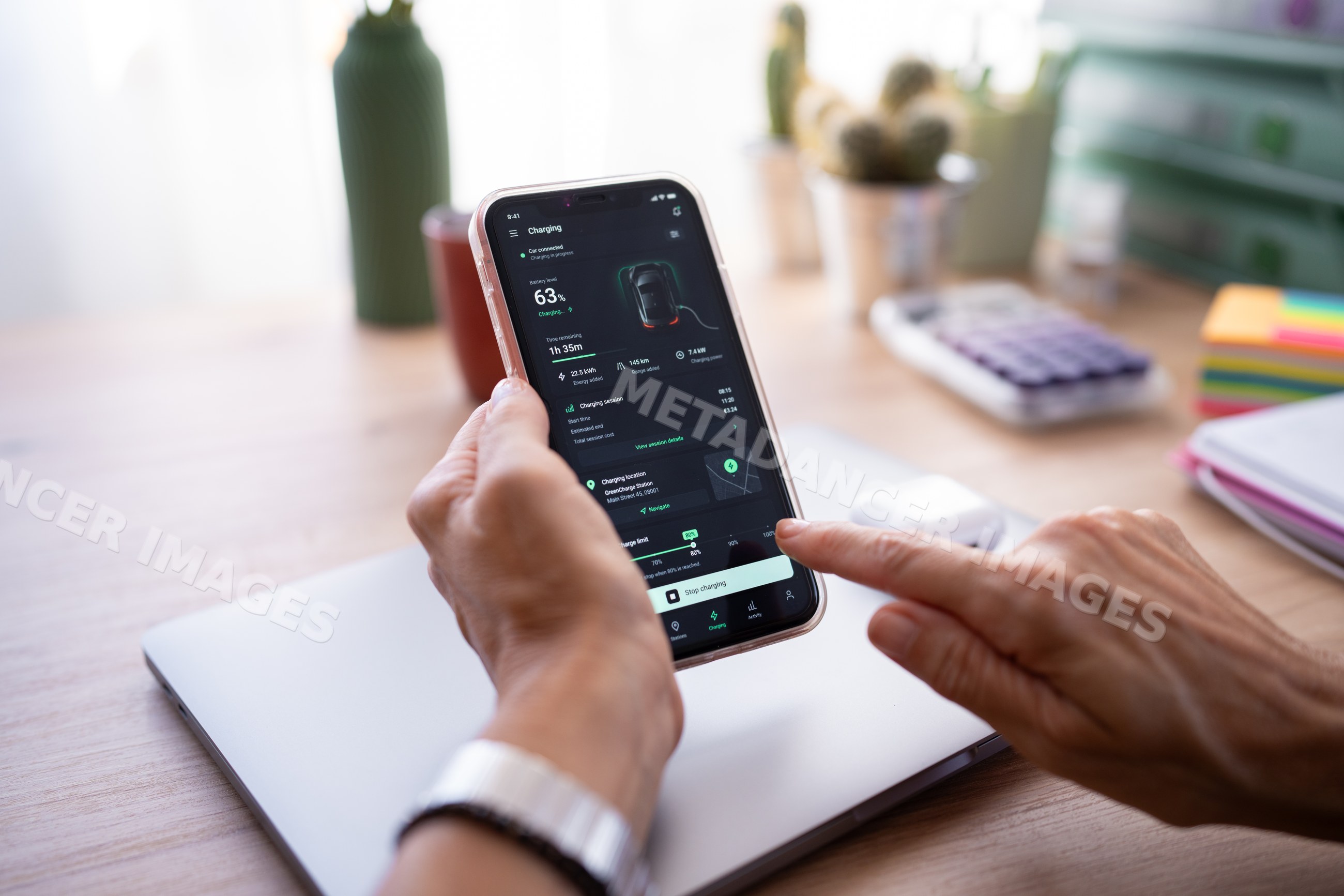 White person monitoring electric car battery charging on smartphone