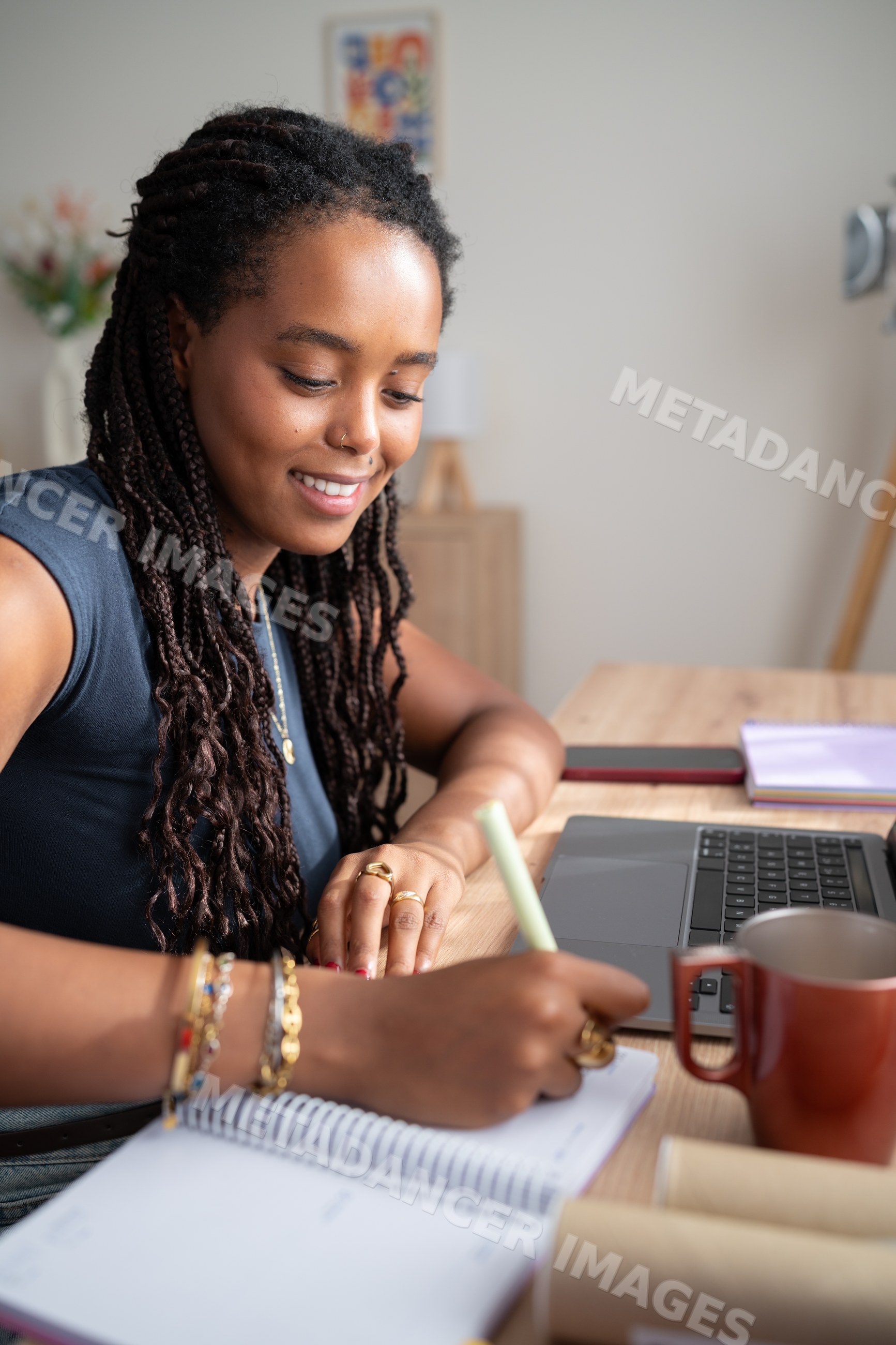 African American woman with braided hair writing notes