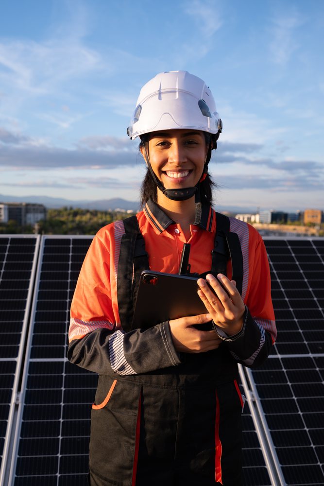 Hispanic woman engineer inspecting solar panels outdoors in Madrid