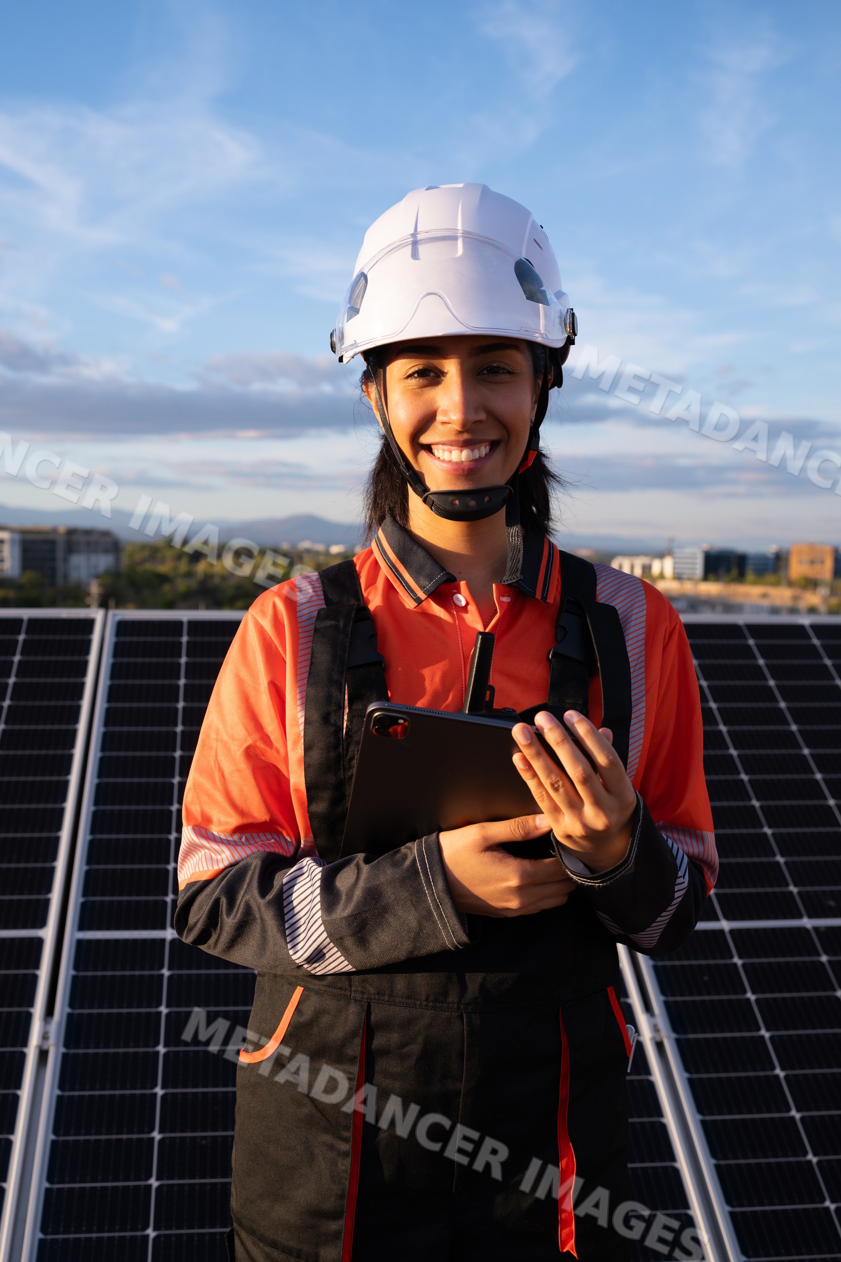 Hispanic woman engineer inspecting solar panels outdoors in Madrid