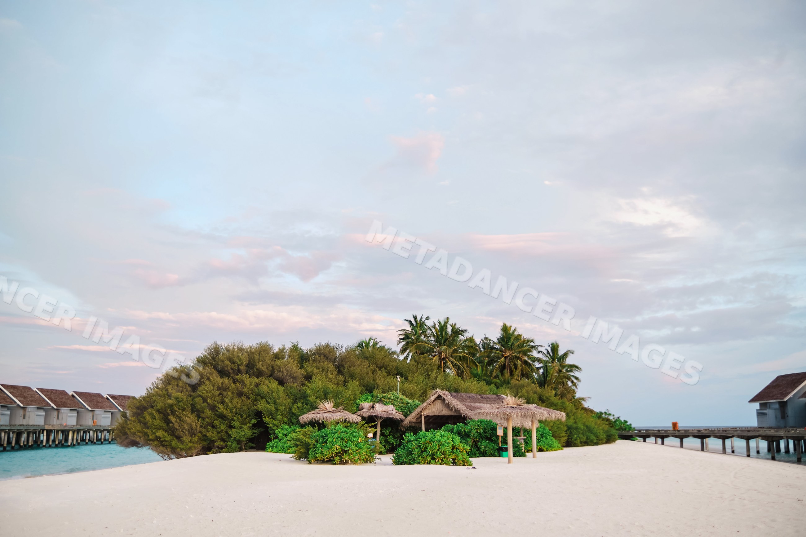 A tranquil tropical island beach with thatched huts and palm trees