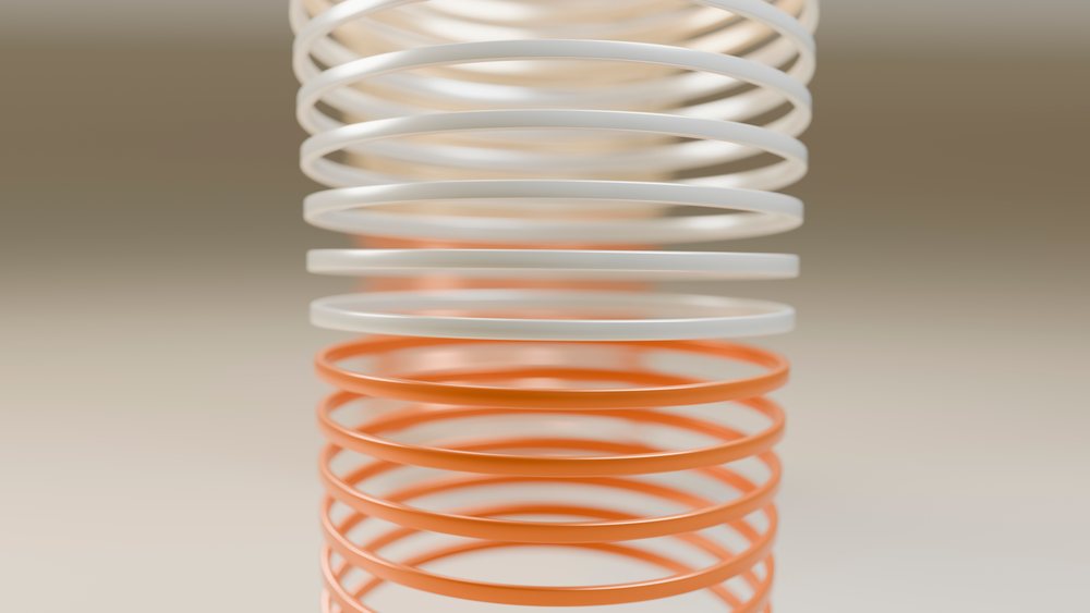 Vertical stack of white and orange coil springs