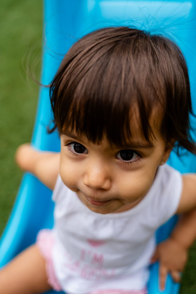 Young white girl enjoying outdoor play on blue slide
