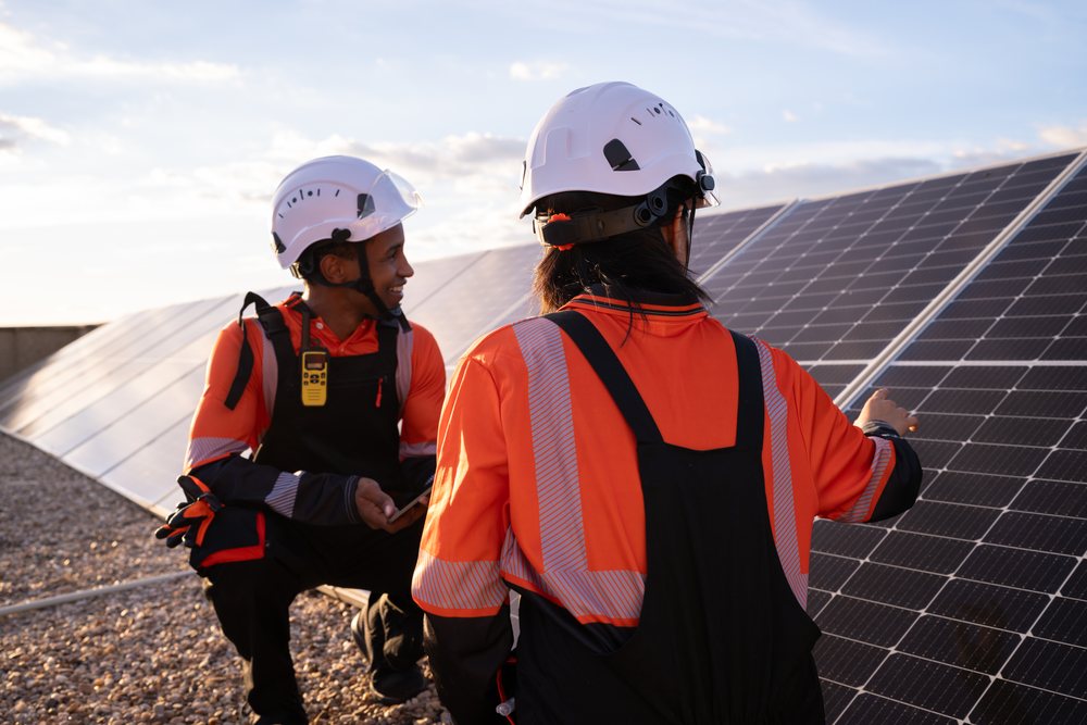 Solar energy Hispanic workers inspecting photovoltaic panels outdoors