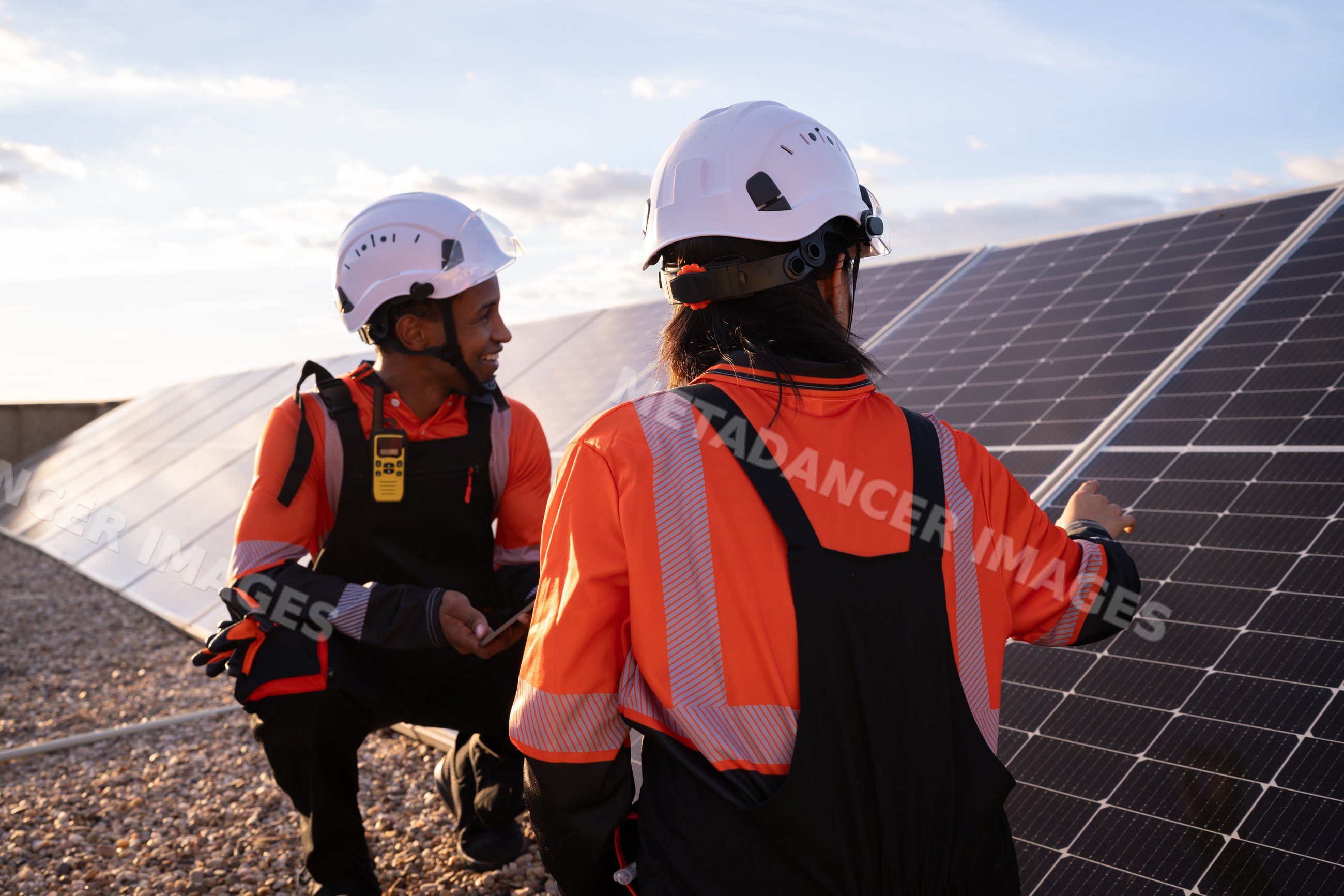 Solar energy Hispanic workers inspecting photovoltaic panels outdoors