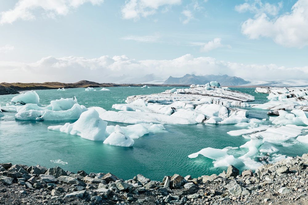 Icebergs floating in a glacial lagoon with rocky shores