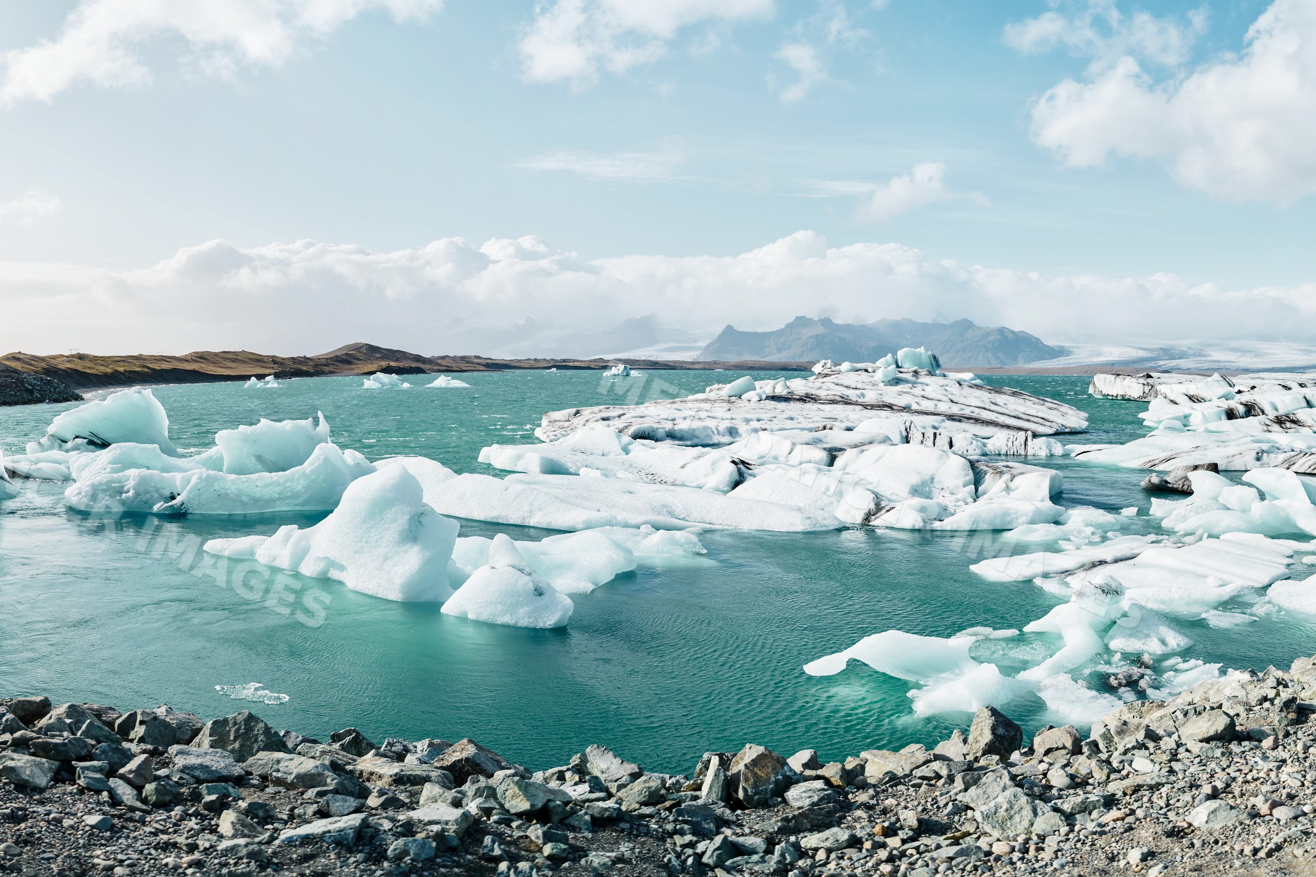 Icebergs floating in a glacial lagoon with rocky shores