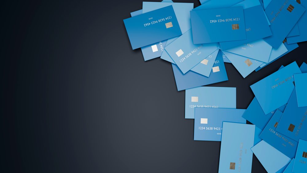 Pile of blue credit cards scattered on dark background
