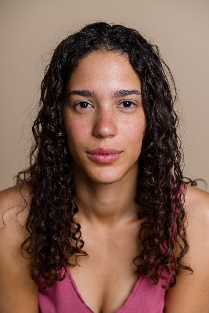 Hispanic woman with curly hair in beauty shoot studio