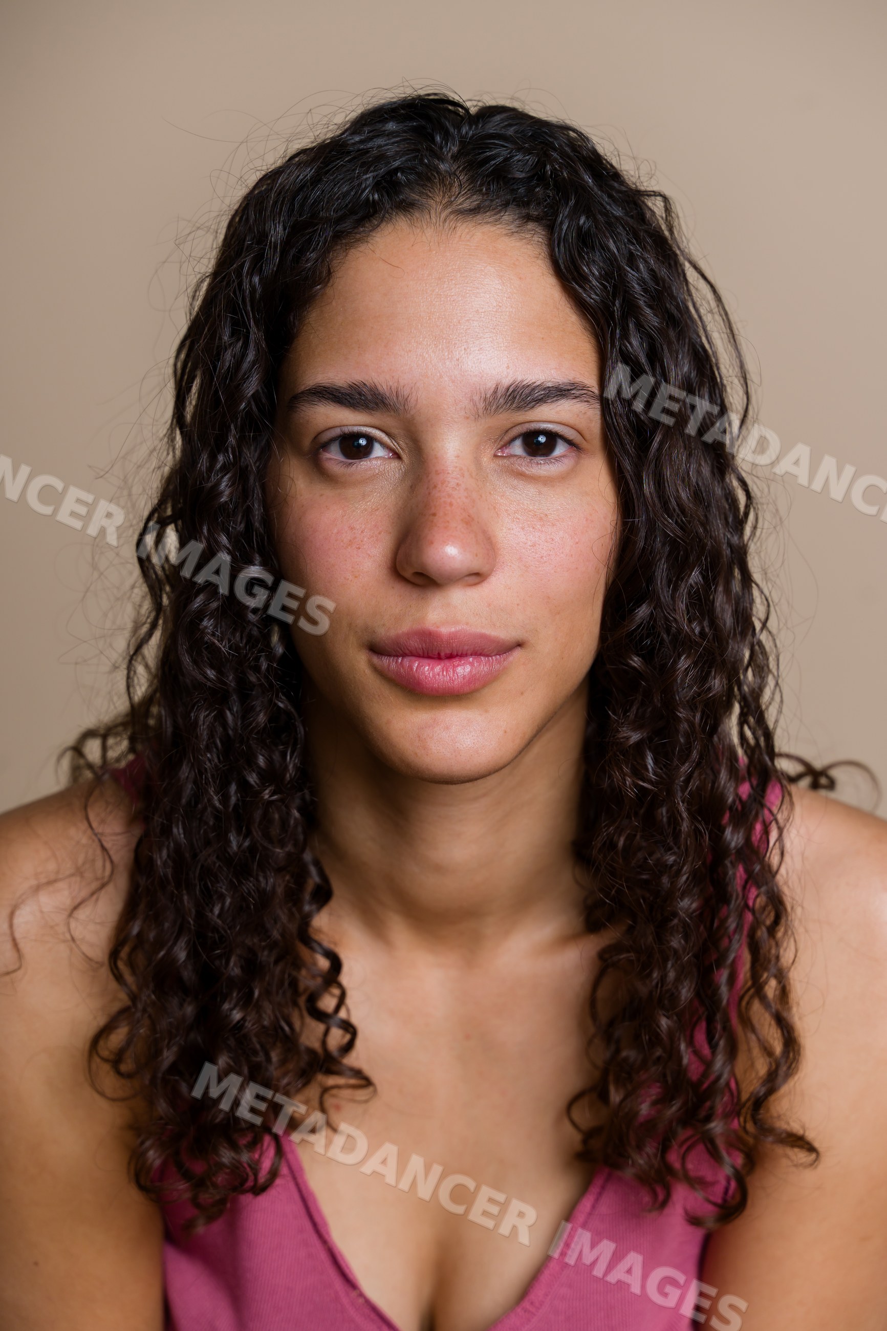 Hispanic woman with curly hair in beauty shoot studio