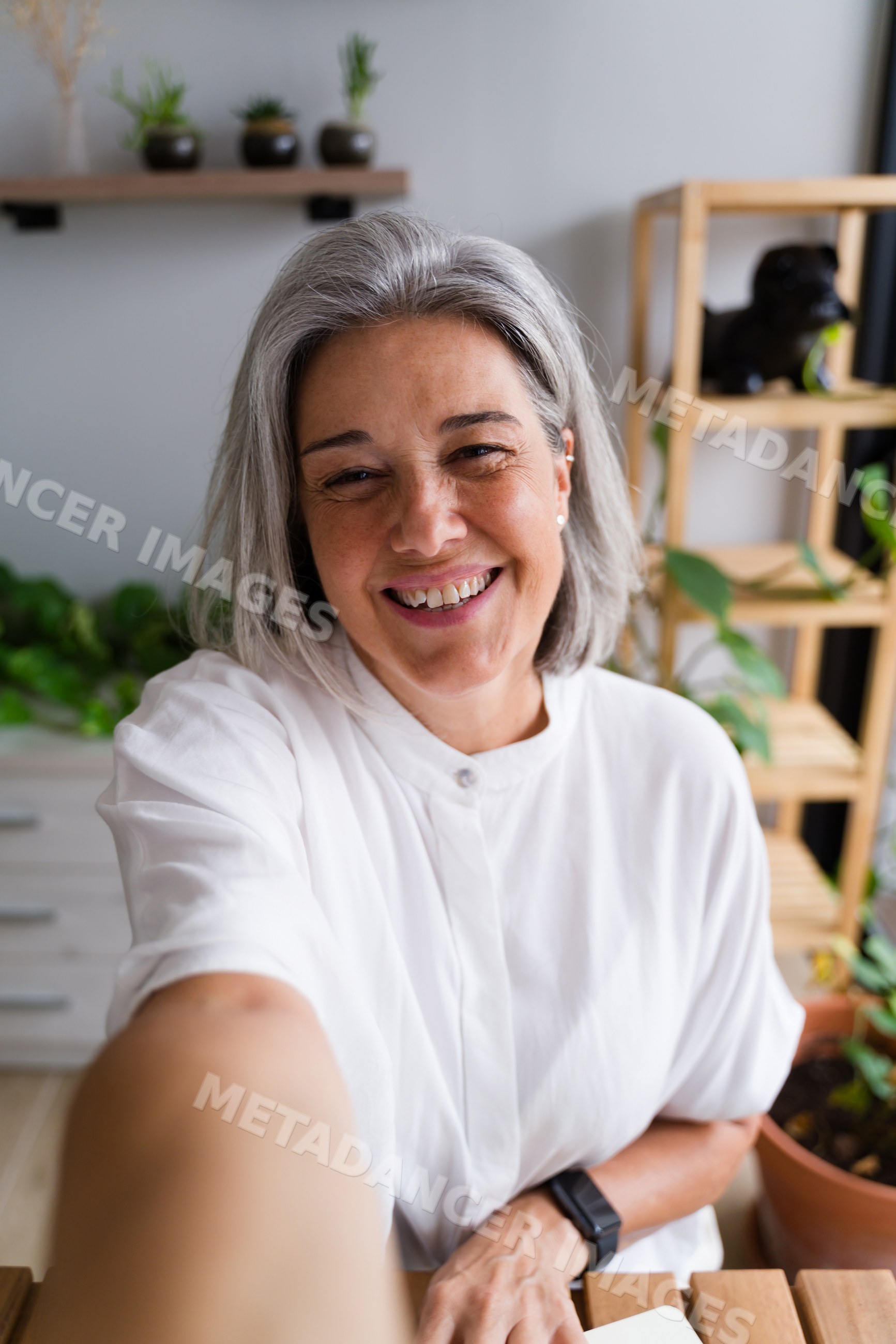 White Woman smiling taking a selfie at home with plants around